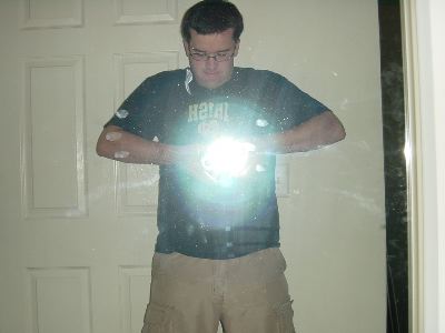 Pete facing the mirror, holding a camera such that the flash looks like a magic orb in his hands