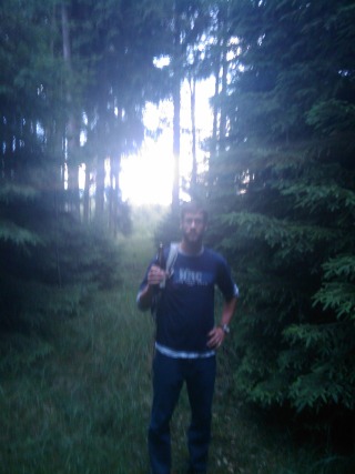 Dan standing in the woods with a beer