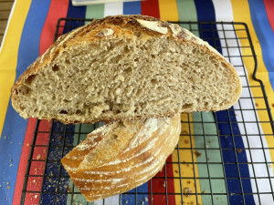 Cut loaf of sourdough bread on a cooling rack showing the crumb structure