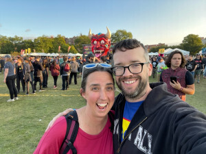 Jamie and Pete in front of a Devil sign at Riot Fest