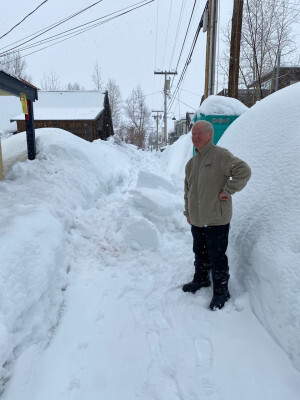 Dad standing in the alley in front of the gallery, surrounded by snow 