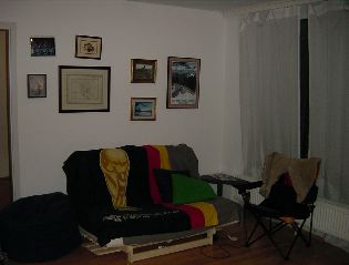 Futon, bean bag, and camping chair with pictures on the wall behind them