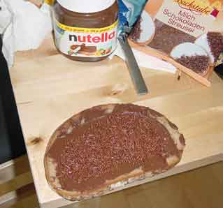 A slice of bread with Nutella and chocolate sprinkles on it