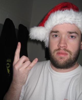 Pete wearing a Santa hat and making the sign of the horns with his hand