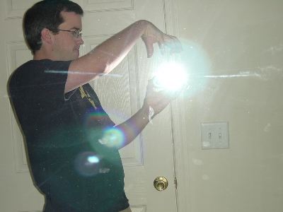 Pete in front of the mirror facing sideways, holding a camera such that the flash looks like a magic orb in his hands