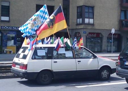 Car with large German and Bavarian flags and smaller flags of other countries