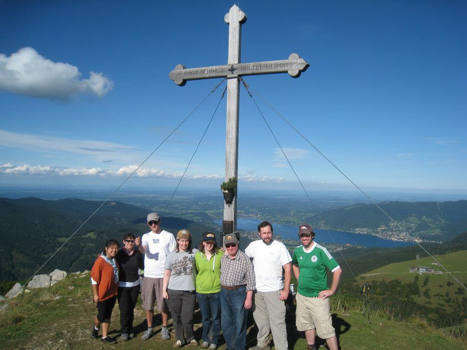 Group of hikers in front of the cross at the top of the Hirschberg