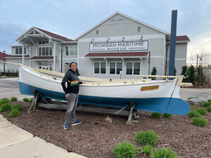Jamie standing next to a boat in front of the Michigan Maritime Museum 